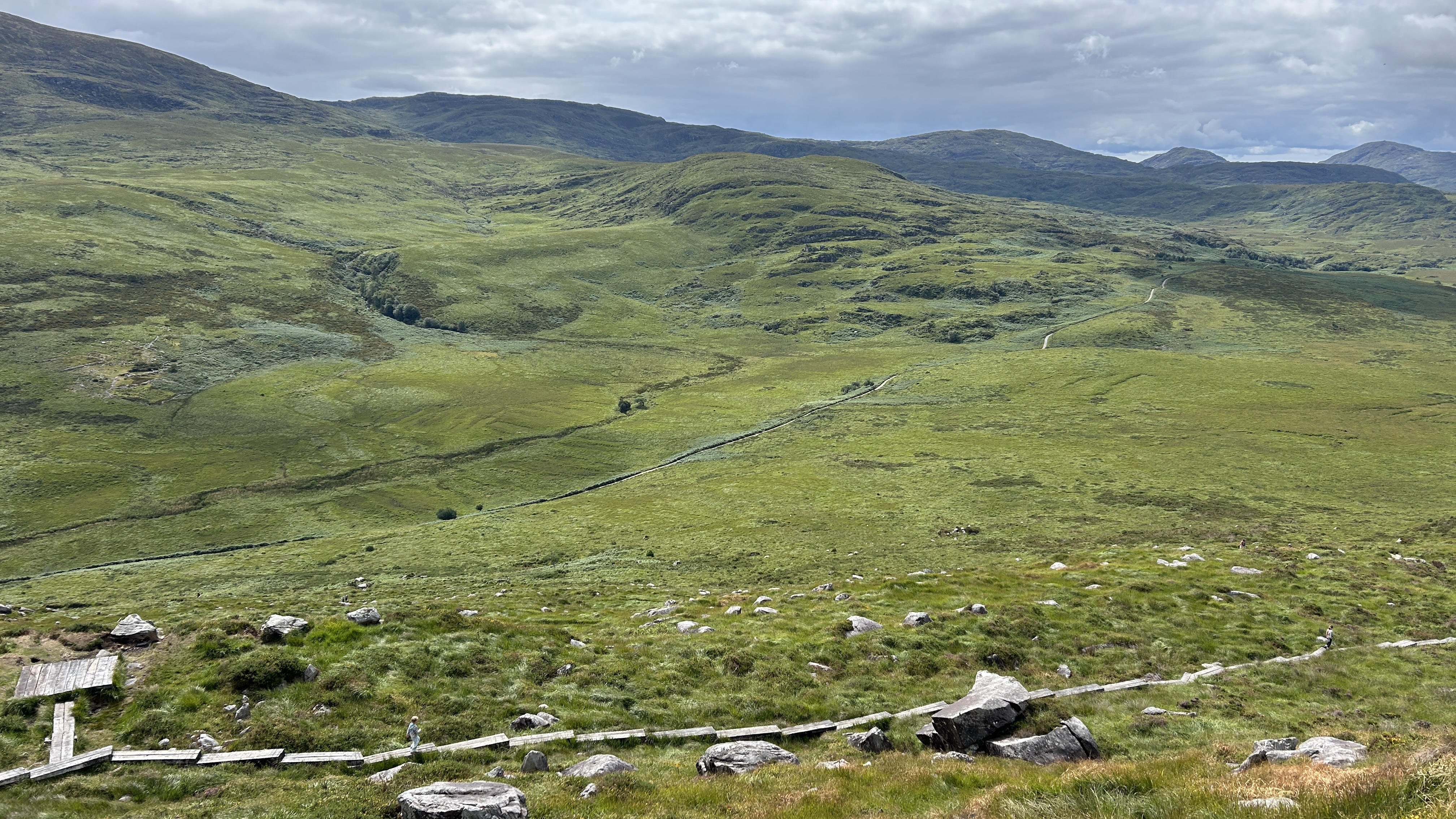 Green mountain valley crossed by a winding wooden boardwalk