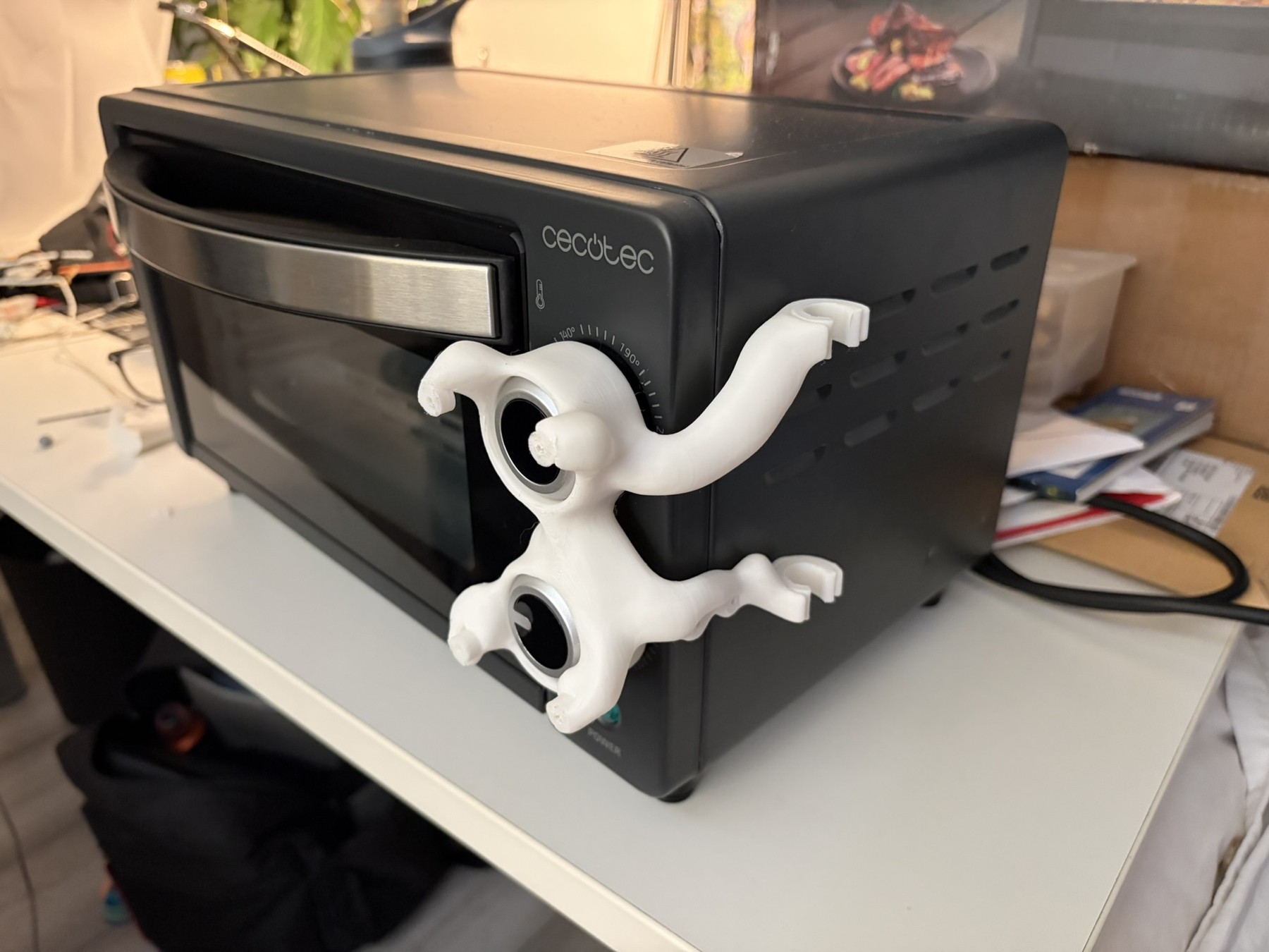 The printed bracket pressed onto the oven dials before fitting the display