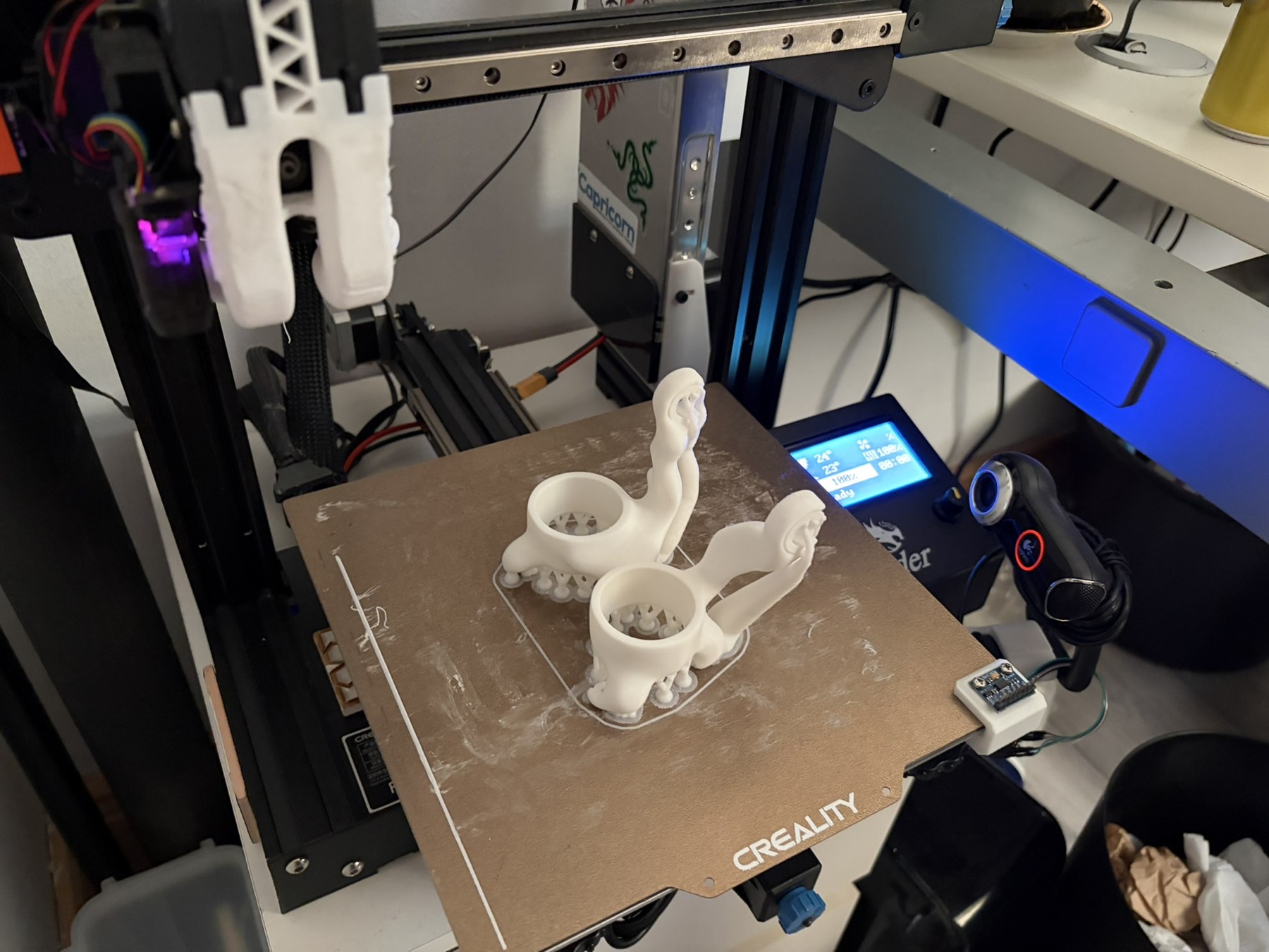 White bracket parts on the build plate of the modified Ender 3 Pro