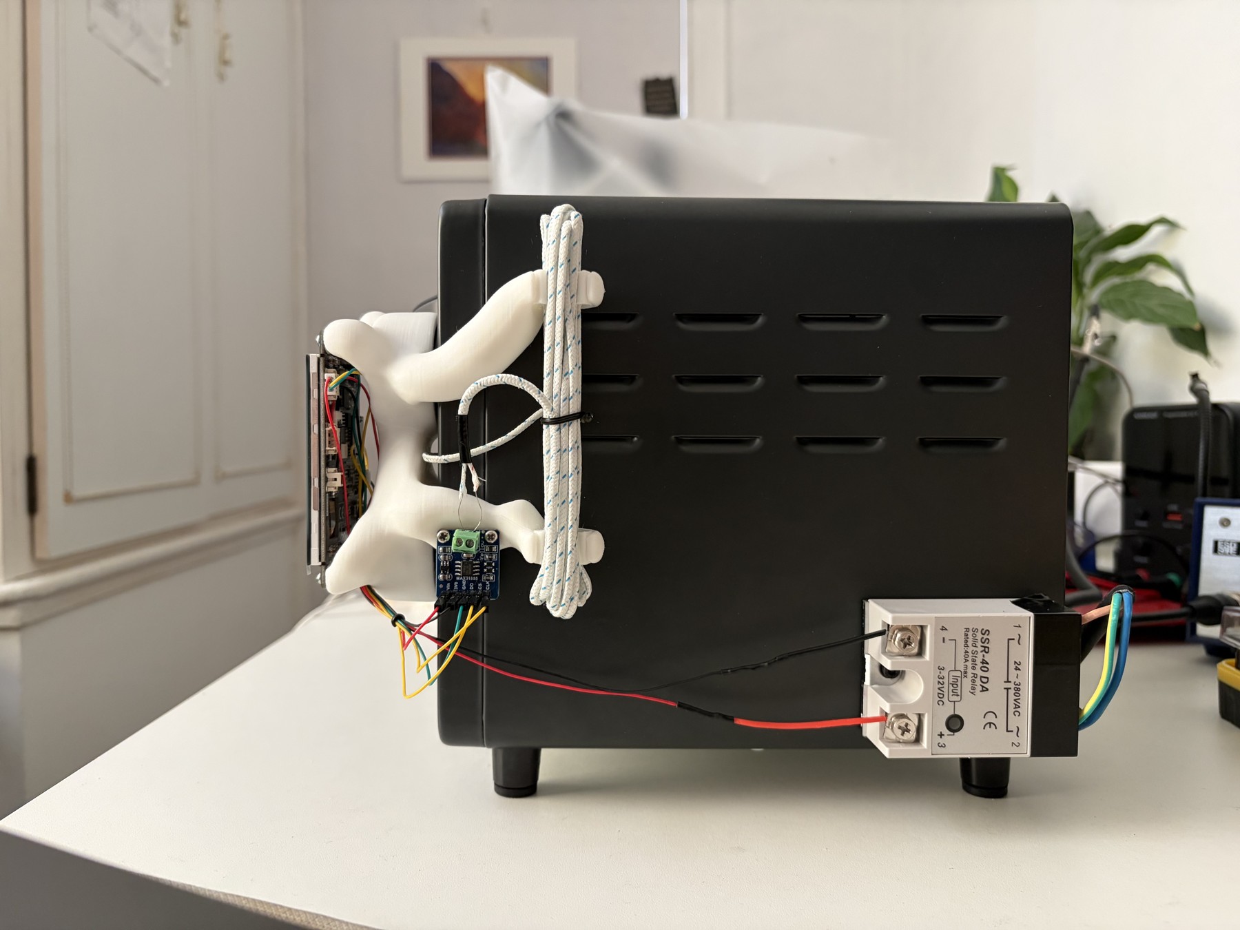 Side view of the oven showing the exposed low-voltage controller and relay mounted near the lower rear corner