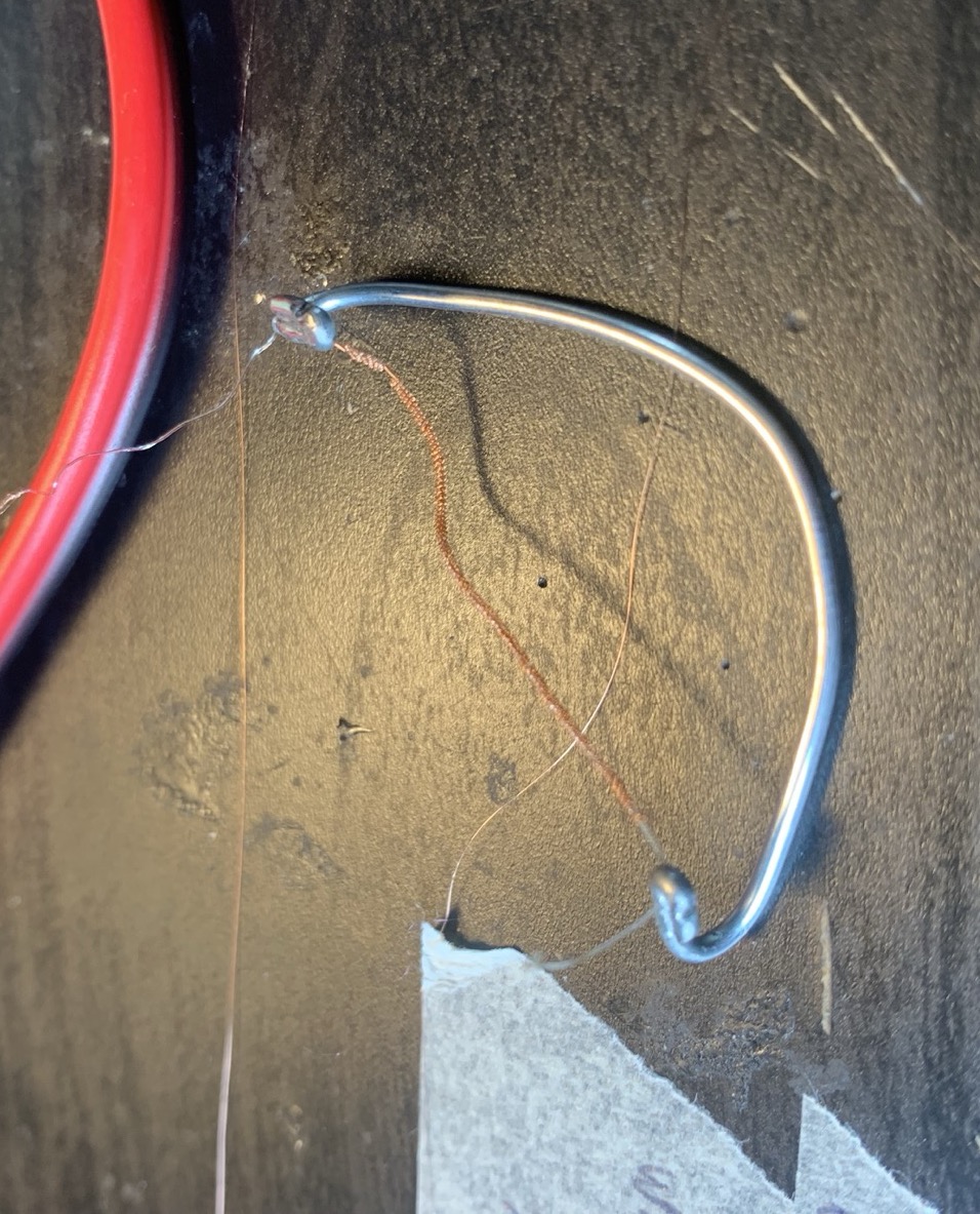 A copper-wrapped supercoil held under slight extension on a wire hook
