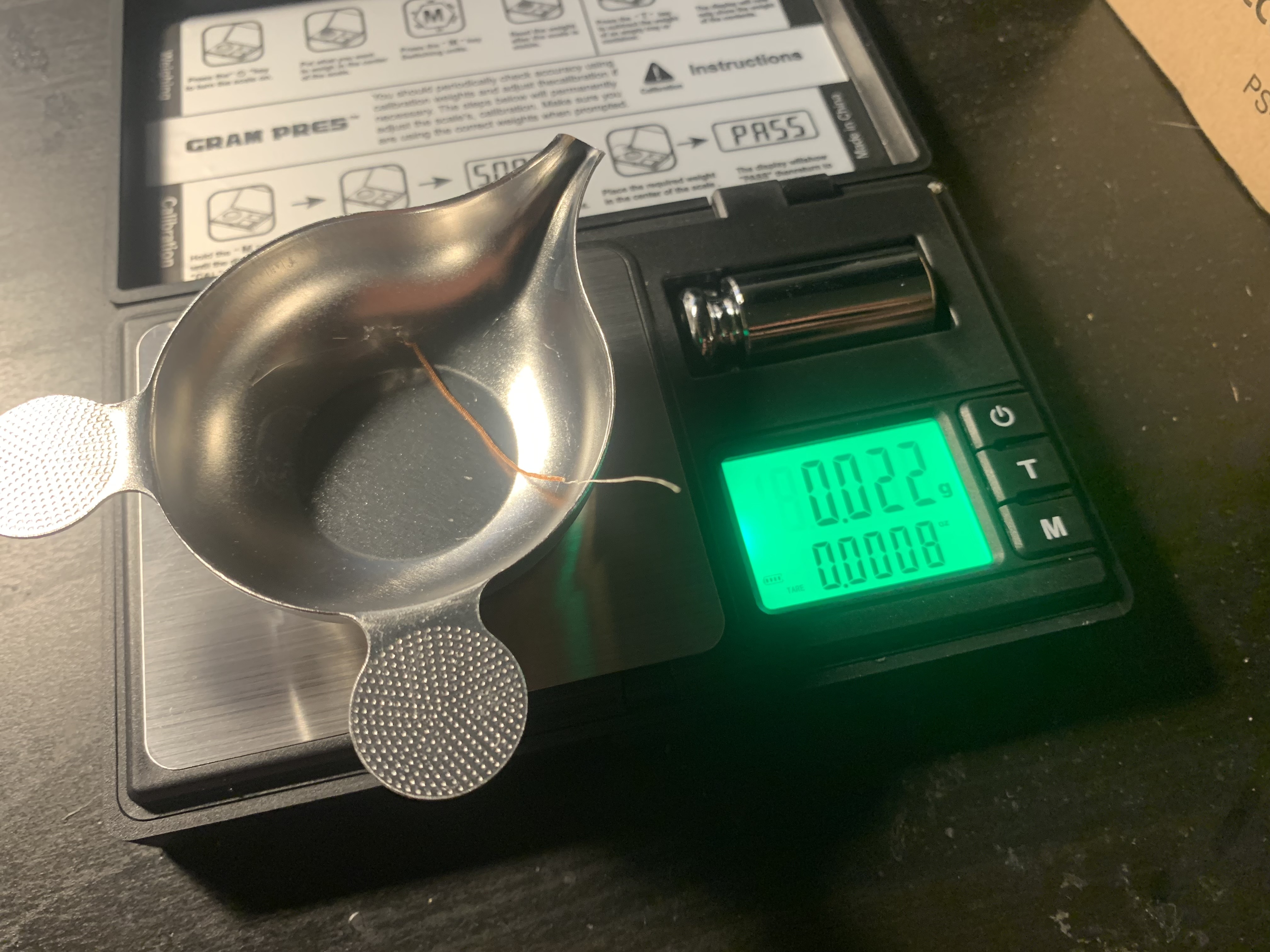 A finished artificial muscle reading 0.022 grams on a milligram scale